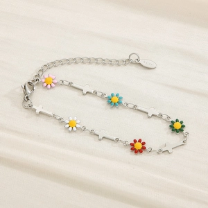 Detailed view of colorful enamel daisy charms and silver cross links on a steel bracelet