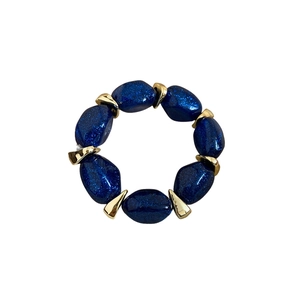 Acrylic oval beaded bracelet with deep blue glitter finish and golden geometric spacers