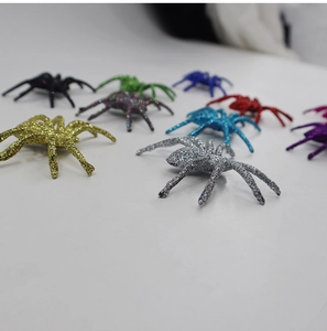 Close-up of assorted multi-color glitter plastic spiders for Halloween party decor