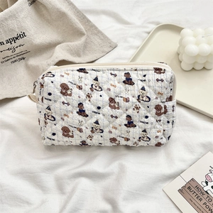 Detailed view of a quilted makeup bag with cartoon puppy prints and zipper closure