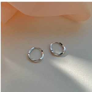 Macro detail of S925 sterling silver stamp on minimalist twisted hoop earrings