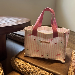 Dettaglio borsa trapuntata a righe bianche e rosa con stampe di cani e ciliegie carine