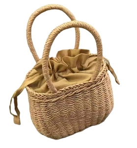 Khaki straw woven bucket bag with drawstring closure and top handles on white background