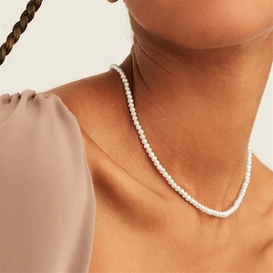Elegant 14K gold plated necklace with small white pearls on model collarbone