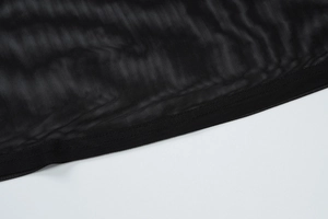 Macro view of black mesh fabric detailing and high-quality edge stitching on a dress