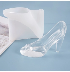 Detail of high heel silicone mold with a finished clear resin shoe and bow accents