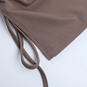 Detailed close-up of brown ribbed knit fabric with drawstring and precision stitching