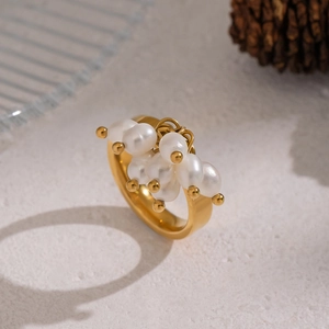 Eleganter Ring aus vergoldetem Edelstahl mit natürlichen Süßwasserperlen auf beigem Hintergrund