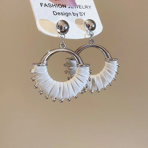 Detail of silver hoop earrings featuring white leather wrap and delicate metal bead trim