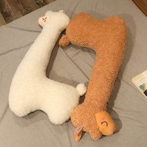 Detail of long alpaca plush pillow in white and brown soft lamb wool fabric