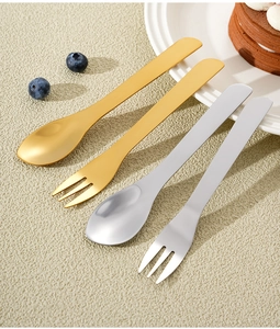 Close-up of gold and silver stainless steel dessert spoons and forks for coffee and cake
