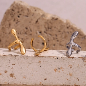Polished 18K gold and silver cross ear clips with irregular fluid metal design on stone