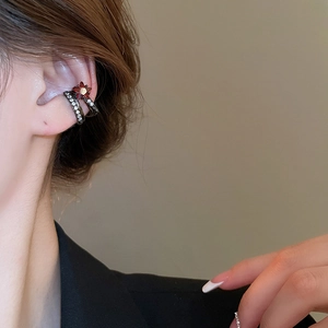 Gros plan d'un ear cuff double couche or noir avec cristaux blancs et étoile rouge