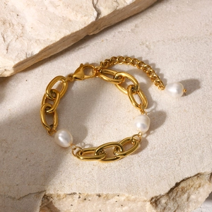 Detail of 18K gold stainless steel bracelet with baroque pearls on stone background