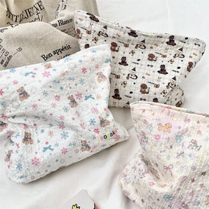 Close-up of quilted cotton makeup bags with cartoon bear and puppy prints for travel storage