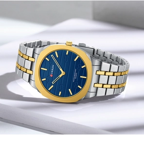 Close-up of thin square quartz watch with blue textured dial and gold-silver steel band