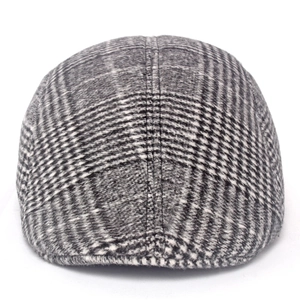 Detail shot of the thick wool blend grey plaid fabric and stitching on the newsboy cap