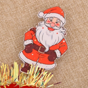 Détail du Père Noël décoratif avec franges dorées sur fond de toile de jute texturée