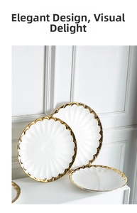 Close-up of luxury white ceramic plate with gold rim and elegant petal-shaped texture