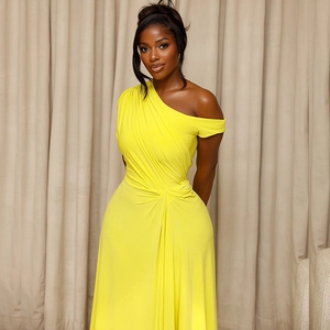 Detailed close-up of bright yellow one-shoulder pleated maxi dress with waist gathering