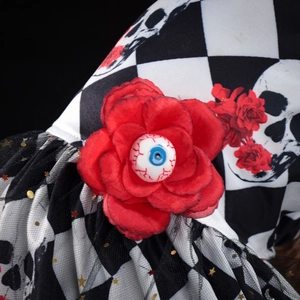 Detailed view of Halloween pet dress with red eye-rose and checkered skull pattern mesh
