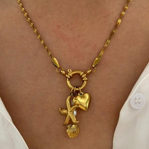 Elegant gold starfish heart and pearl pendant necklace on a model for a chic summer look