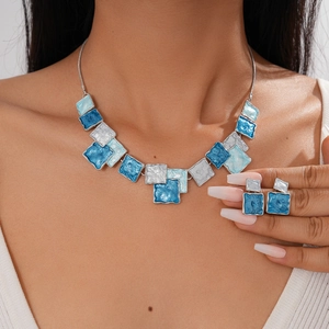 Detail of geometric blue and white enamel pendant necklace and matching earrings
