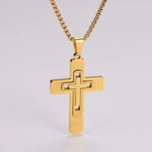 Close-up of golden double-layer cross pendant with textured finish on box chain necklace