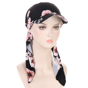 Detail of floral headscarf hat with pink patterns on black fabric and long straps