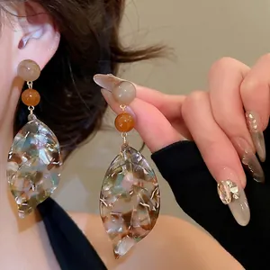 Vintage tortoiseshell leaf drop earrings with amber resin beads worn on model