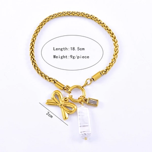 Detail of a gold braided bracelet with bow, zircon and pearl charms, size 18.5cm long