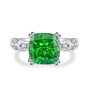 Radiant cut emerald green silver ring featuring sparkling side stones on a white background