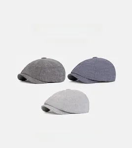 Detailed weave of newsboy caps in dark grey, blue-grey, and light grey shades