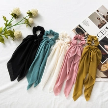 Flat lay of five colorful bow hair scrunchies in chiffon fabric on a stylish background