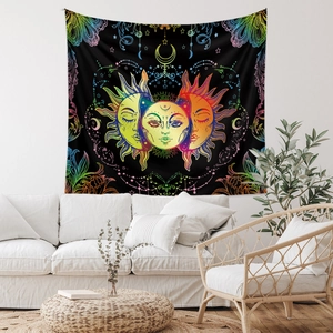 Detail of bohemian sun and moon tapestry hanging above a white sofa in a living room