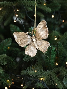 Dettaglio di un elegante ornamento a farfalla dorata appeso a un albero di Natale festoso
