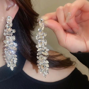 Détails de boucles d'oreilles de luxe en argent avec cristaux et pampilles longues