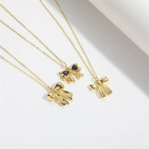Elegant gold bow pendant necklace with black heart gemstone on minimalist thin chain