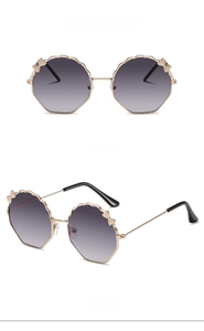 Détail de lunettes de soleil enfants avec monture dorée et verres gris dégradés