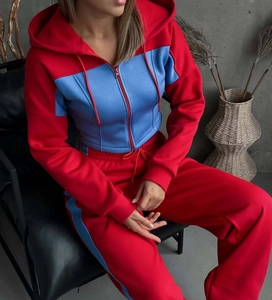 Dettaglio della tuta bicolore rosso e azzurro con cappuccio e pantaloni sportivi