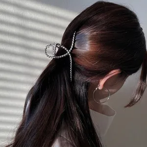 Silver metallic large shark hair claw with twisted spiral design on female model
