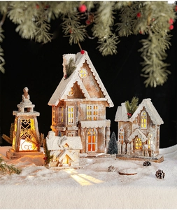 Close-up of lighted miniature wooden Christmas village houses with snowy details