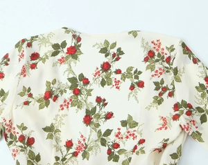 Close-up of red rose floral print on cream chiffon fabric with delicate texture