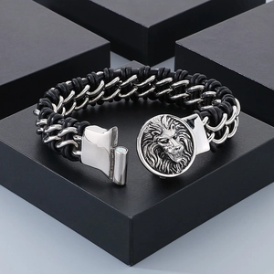 Macro detail of braided black leather bracelet with silver lion head magnetic clasp