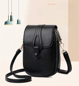 Close-up of black litchi pattern leather phone bag with gold hardware and zipper detail