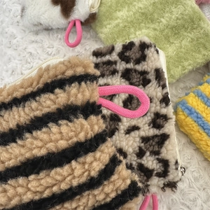 Detail of assorted plush coin purses featuring zebra, leopard, and cow prints with zippers