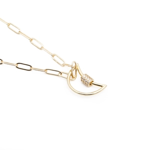 Macro detail of gold-plated paperclip chain necklace with zircon-encrusted D-shaped screw lock