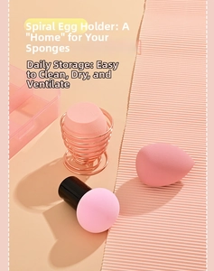 Close-up of rose gold spiral drying rack with pink beauty sponges and makeup puffs