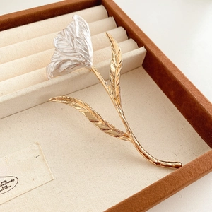 Detailed macro view of artistic flower brooch with silver petals and golden stems