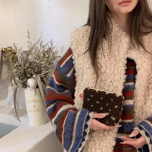 Brown plush pouch with white dots and pink zipper pull held by model in warm autumn outfit